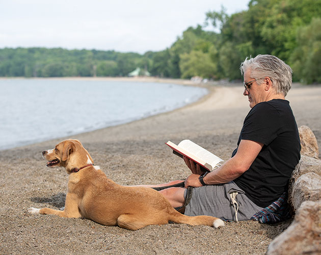 Man with dog enjoying the beach