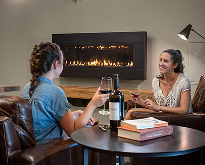 woman in front of fireplace enjoying drinks